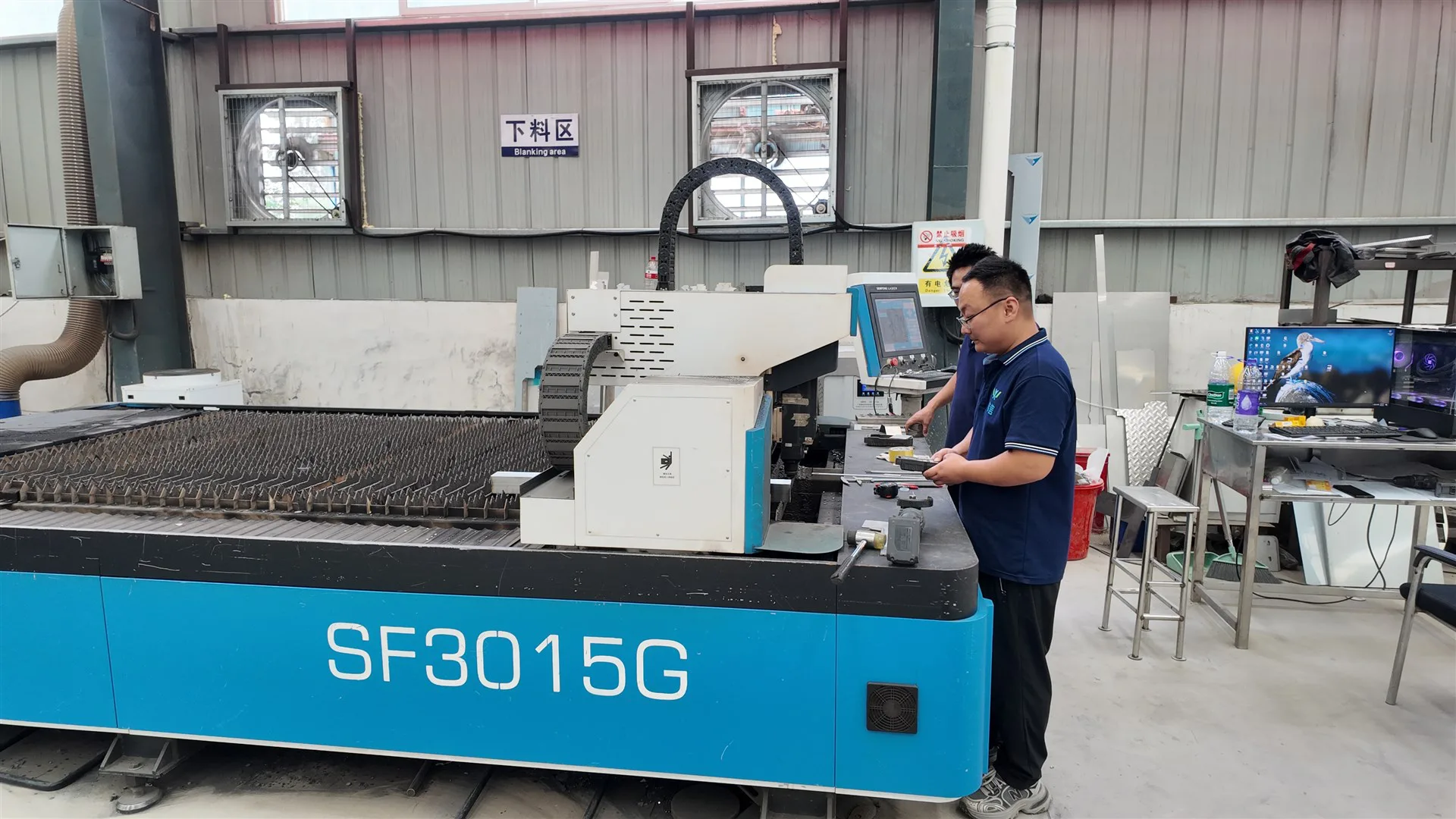 Technician operating laser cutting equipment in the workshop